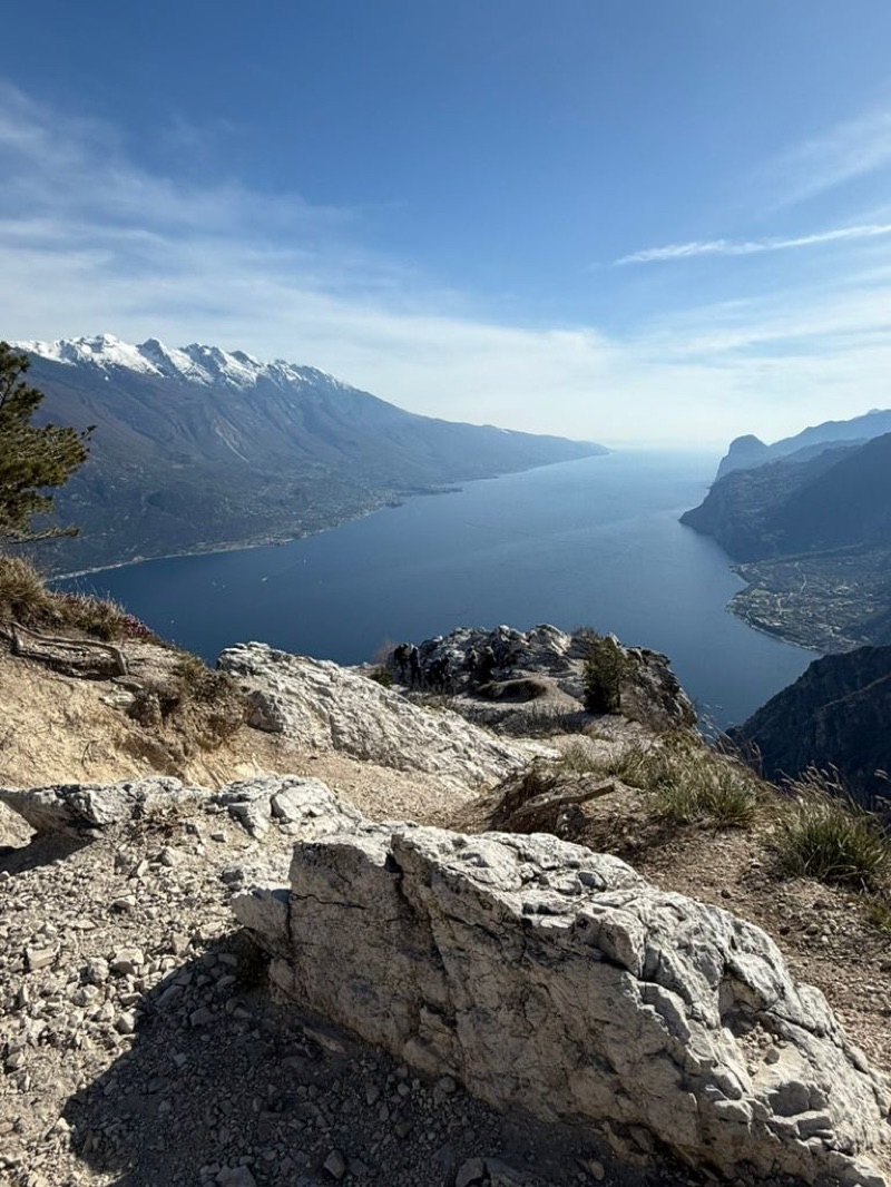 Bike at cliff edge with snow-capped Monte Baldo